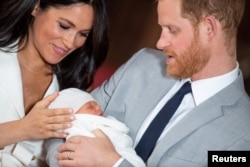 FILE - Britain's Prince Harry and Meghan, Duchess of Sussex, hold their baby son in St. George's Hall at Windsor Castle, in Berkshire, Britain, May 8, 2019.
