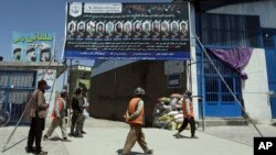 Foto-foto siswa yang terbunuh dari Sekolah Syed Al-Shahada dipajang di gerbang sebuah masjid di lingkungan Dasht-e-Barchi di Kabul, Afghanistan, 1 Juni 2021. (AP Photo/Rahmat Gul)