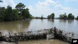 FILE - A barbed-wire fence encircles the Highlands Acid Pit that was flooded by water from the nearby San Jacinto River as a result from Harvey in Highlands, Texas, Aug. 31, 2017. 