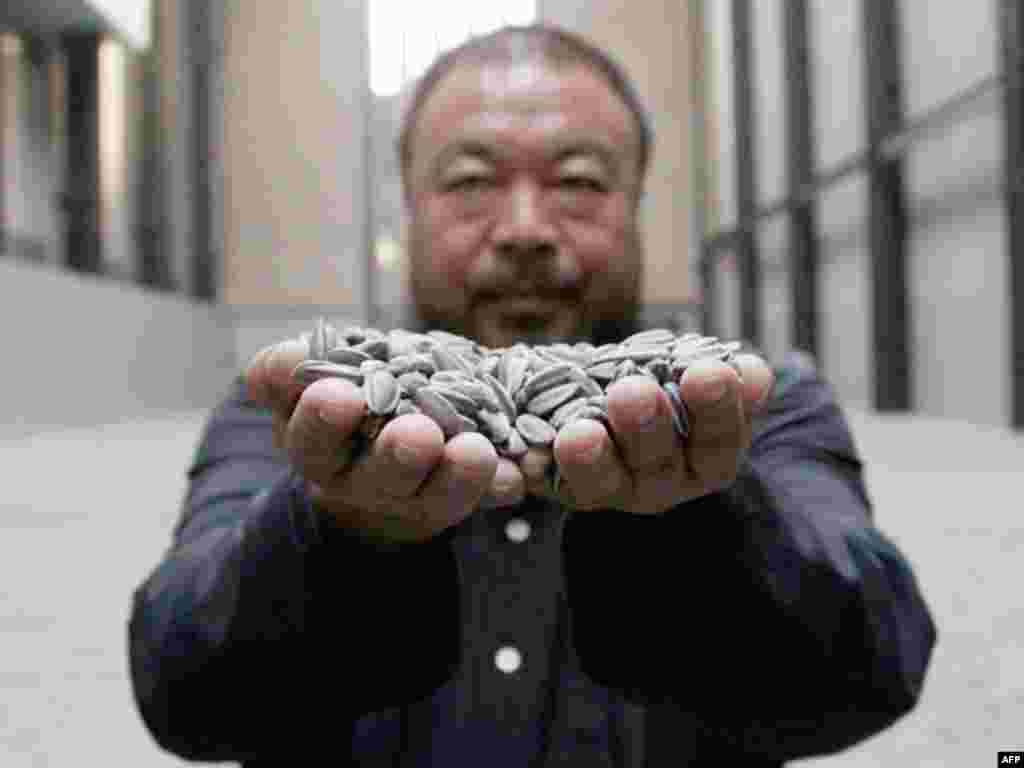 Chinese artist Ai Weiwei was named Most Powerful Artist by ArtReview magazine. He poses for a photograph with his new installation entitled 'Sunflower Seeds', at its unveiling in the Turbine Hall at the Tate Modern gallery, in London October 11, 2010.