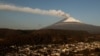 Una nube de cenizas y vapor emerge del volcán Popocatépetl se observa en esta foto desde el poblado de Santiago Xalizintla, en México, el 12 de mayo de 2023.