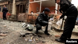 Policemen collect evidence from the site of a bomb attack at the district court in Islamabad, Pakistan, Mar. 3, 2014. 