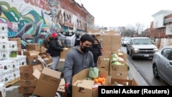 Alex Ramon menyiapkan kotak makanan di dapur nirlaba New Life Center di Chicago, Illinois, AS, 16 Maret 2021. (Foto: REUTERS/Daniel Acker)