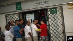 A man offers his queue ticket as people wait in line to enter a government job center in Marbella, Spain, September 2, 2011.