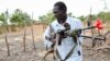 FILE - An opposition fighter walks with his weapon in Akobo town, South Sudan, Jan. 21, 2018.