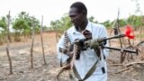 FILE - An opposition fighter walks with his weapon in Akobo town, South Sudan, Jan. 21, 2018.