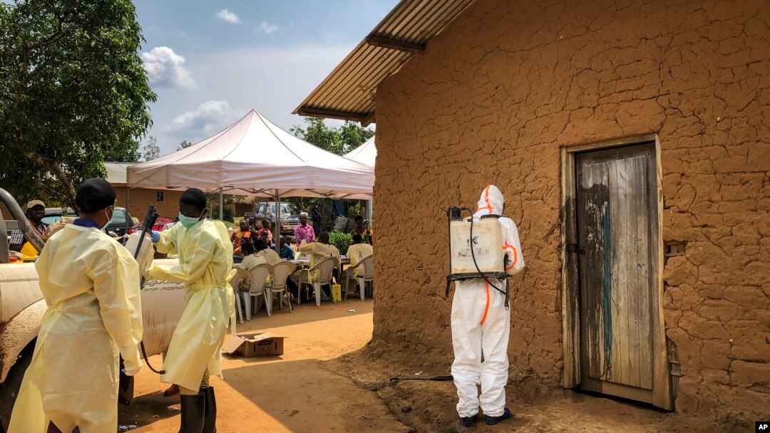 Petugas medis dari Organisasi Kesehatan Dunia (WHO) mendekontaminasi pintu sebuah rumah di desa Mabalako, di Kongo timur, di mana dua kasus Ebola ditemukan, Senin, 17 Juni 2019. (Foto: dok).