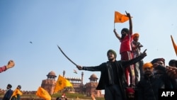 Protesters shout slogans in front of the Red Fort as farmers continue to protest against the central government's recent agricultural reforms in New Delhi on January 26, 2021. (Photo by Sajjad HUSSAIN / AFP)