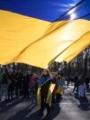 FILE - A woman waves a giant Ukrainian flag during a protest to mark two years since Russia's full-scale invasion on Ukraine, at the Brandenburg Gate, in Berlin, Saturday, Feb. 24, 2024. 