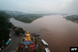 FILE - A giant Buddha on the Thai side of the Golden Triangle in Chiang Rai province, is seen with Myanmar in the background and Laos on the right, Sept. 20, 2019.