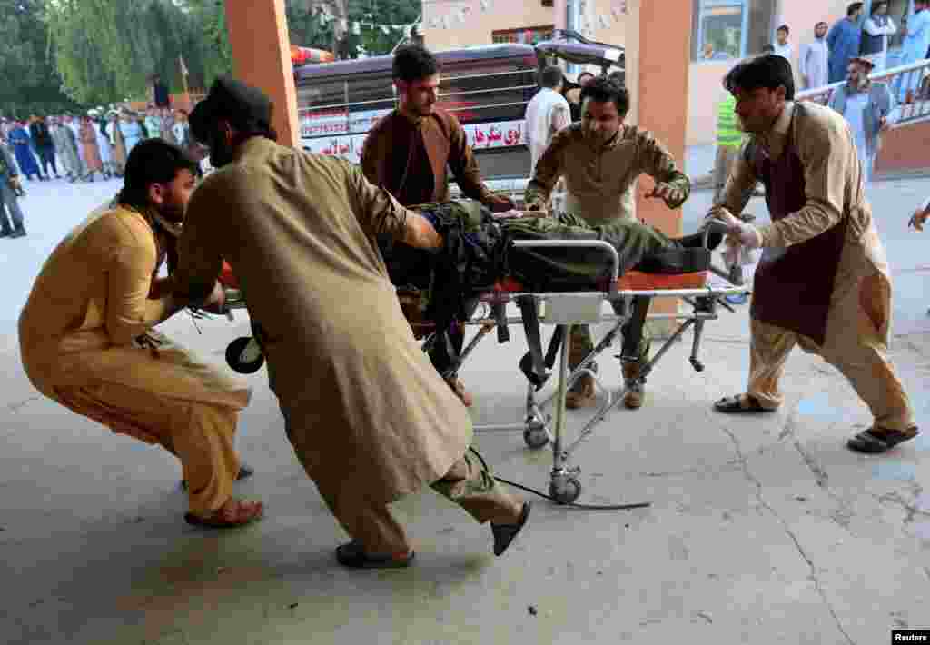 Men carry a wounded person to a hospital after an explosion in Jalalabad, Afghanistan.