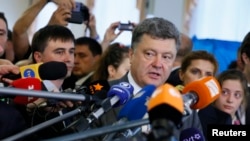 FILE - Ukrainian President Petro Poroshenko (C), a presidential candidate at the time, speaks to journalists in Kyiv, May 25, 2014. Recently, Poroshenko has raised eyebrows urging journalists not to write “negative articles about Ukraine.” 