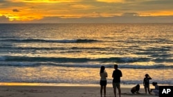 Tourists stand on Bang Tao Beach in Phuket, southern Thailand, Oct. 22, 2021. 