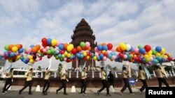 Students hold balloons as they walk past the Independence Monument during celebrations marking the 62nd anniversary of the country's independence from France in central Phnom Penh, Cambodia November 9, 2015. REUTERS/Samrang Pring - RTS631R