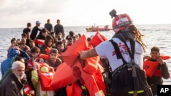 FILE - Migrants are rescued from the sea some 30 miles off Libya by the members of the humanitarian ship Geo Barents, October 6, 2023.