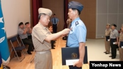 30일 서울 국방부 내 합동수행모의본부에서 열린 '합동참모본부 창설 제51주년 기념식'에서 최윤희 합참 의장(왼쪽)이 유공자에게 포상하고 있다.