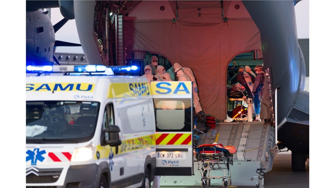 This French army photo provided April 4, 2020, shows coronavirus patients from Paris being loaded into ambulances in Clermont Ferrand the day before. France has moved patients around the nation to ease the strain on congested Paris hospitals.
