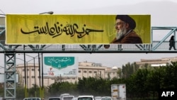 FILE - A large banner bearing a picture of Lebanon's Hezbollah leader Hassan Nasrallah with writing in Farsi that reads 'Hezbollah is alive' hangs along a bridge in northern Tehran, Sept. 28, 2024.