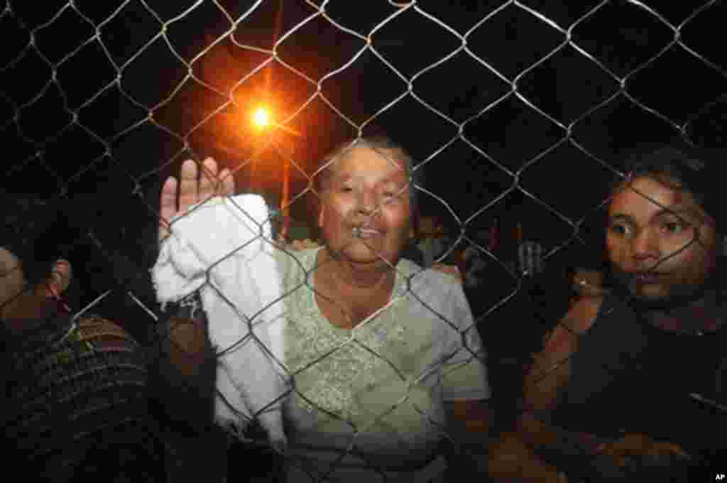 Inmates' relatives stand at the gates of the prison in Comayagua, Honduras, after a fire broke out inside the prison early February 15, 2012. Radio reports from Comayagua said dozens of prisoners were burned beyond recognition and the prison was destroyed