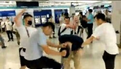 Men in white T-shirts and face masks attack anti-extradition bill demonstrators and reporters at a train station in Hong Kong, China, July 21, 2019, in this still image obtained from a social media live video.