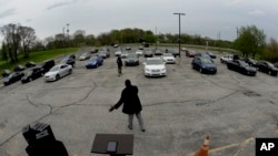 FILE - In this April 12, 2020, photo, Pastor W.R. Starr II preaches during a drive-in Easter Sunday service while churchgoers listen from their cars in the parking lot at Faith City Christian Center in Kansas City, Kan.