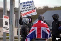 FILE - Pro-Union Loyalists demonstrate against the Northern Ireland Protocol implemented following Brexit, on the road leading to the Port of Larne in County Antrim, Northern Ireland, April 6, 2021.