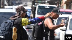 Venezuelan migrants sell candies to continue their journey to the US in Comayaguela, Honduras, on November 6, 2024.