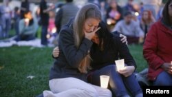 Sisters Heidi Wickersham, left, and Gwendoline Wickersham join in a vigil Saturday for those killed two days earlier at Umpqua Community College, near Roseburg, Ore. The gunman killed nine people before committing suicide, Oct. 1, 2015.