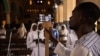 ARCHIVES - Un homme utilise un téléphone pour diffuser en direct sur les réseaux sociaux la messe traditionnelle du dimanche de Pâques à la cathédrale de l'Immaculée Conception à Ouagadougou, au Burkina Faso, le 12 avril 2020.