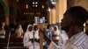 FILE - A man uses a phone to broadcast the traditional Easter Sunday mass live on social media at the Cathedral of the Immaculate Conception in Ouagadougou, Burkina Faso, April 12, 2020. 