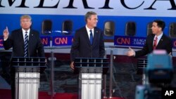 Wisconsin Gov. Scott Walker, right, speaks as Donald Trump, left, reacts and former Florida Gov. Jeb Bush listens during the CNN Republican presidential candidates debate in Simi Valley, Calif., Sept. 16, 2015.