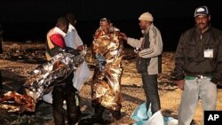 Migrants receive assistance as they arrive on the tiny island of Lampedusa, Italy, May 8, 2011 (file photo).