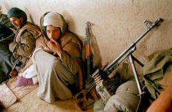 FILE - Taliban fighters huddle in a front line shelter during a lull in fighting south of Kabul, Afghanistan, March 22, 1995.