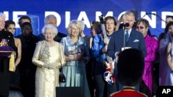 Britain's Prince Charles and Queen Elizabeth II are joined on stage with the rest of the Royal family as well as performers at the Queen's Jubilee Concert in front of Buckingham Palace, London, June 4, 2012. 