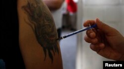 FILE - A man receives a dose of flu vaccine.