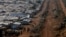 FILE - Internally displaced people gather by a water collection point in a United Nations Mission in South Sudan (UNMISS) Protection of Civilian site (PoC), outside the capital Juba, South Sudan, Jan. 25, 2017.
