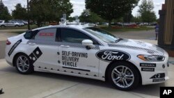 FILE - An Aug. 24, 2017, photo, shows the specially designed delivery car that Ford Motor Co. and Domino’s Pizza will use to test self-driving pizza deliveries, at Domino’s headquarters in Ann Arbor, Michigan. 