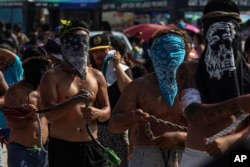 FILE — Filipino flagellants walk along San Pedro Cutud, north of Manila, Philippines, Friday, March 29, 2024, to atone for their sins.