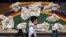 People wearing a protective face mask to help curb the spread of the coronavirus walk in Tokyo Thursday, July 2, 2020. 