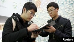 FILE - Student leader Alex Chow, (L) who took part in Hong Kong's Occupy Central or the so-called "Umbrella" movement, signs an autograph for a student from mainland China at Taiwan's Democratic Progressive Party (DPP) headquarters in Taipei, Taiwan, Jan. 14, 2016.