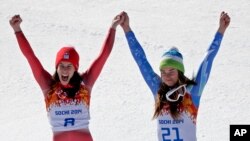 Women's downhill gold medal winners Switzerland's Dominique Gisin, left, and Slovenia's Tina Maze stand together on the podium during a flower ceremony at the Sochi 2014 Winter Olympics, Wednesday, Feb. 12, 2014.
