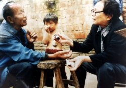 This undated photos shows retired doctor Gao Yaojie, 74, right, applying medicine to a villager's arm as she helps people from neglected AIDS villages in the central China province of Henan.