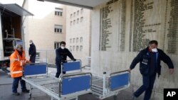 ARCHIVO - En esta foto del viernes 21 de febrero de 2020, personal carga camas nuevas dentro de un hospital de Codogno, cerca de Lodi, en el norte de Italia.