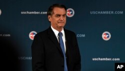 Brazilian President Jair Bolsonaro stands as he is applauded after speaking at the Chamber of Commerce in Washington, March 18, 2019. 