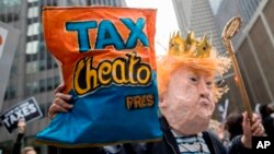 Manifestantes marchan para exigir al presidente Donald Trump que publique sus declaraciones de impuestos el sábado 15 de abril de 2017 en Nueva York.
