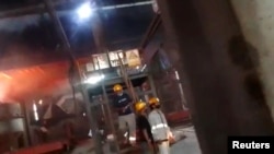 Employees look on amid clashes between Chinese and Indonesian workers at a nickel smelter in Morowali, Sulawesi, Indonesia in this undated social media video released Jan. 16, 2023. Revi Limbong via REUTERS