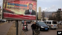 FILE - A billboard shows Chinese President Xi Jinping with the slogan "To exactly solve the problem of corruption, we must hit both flies and tigers," in Gujiao, in northern China's Shanxi province, Feb. 6, 2015.
