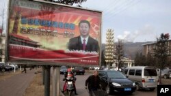 FILE - A billboard shows Chinese President Xi Jinping with the slogan "To exactly solve the problem of corruption, we must hit both flies and tigers" in Gujiao in northern China's Shanxi province. 