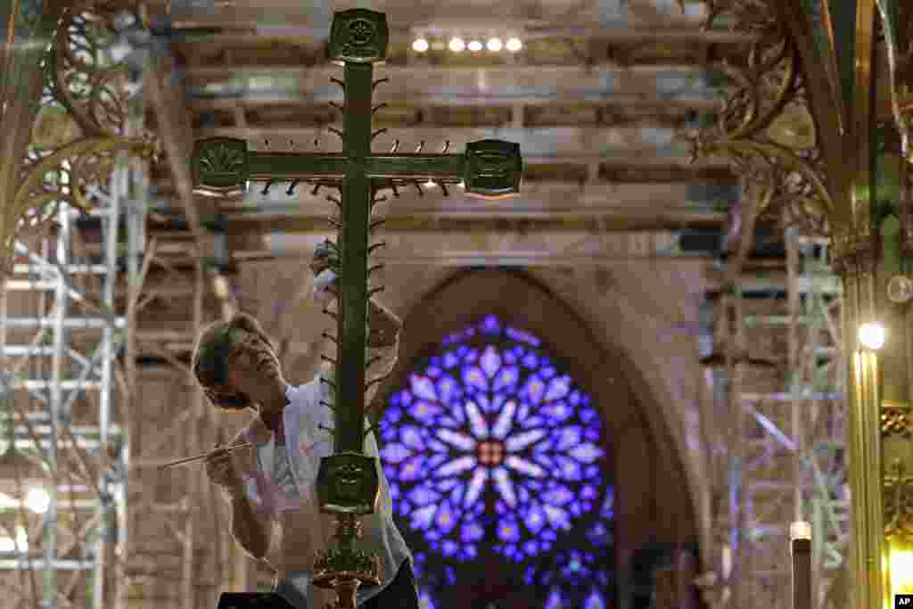 Lucia Popian, president of G&amp;L Popian, cleans and polishes the crucifix on the main altar, as part of the of the ongoing $177 million restoration of St. Patrick&#39;s Cathedral in New York. The renovation, done in three phases over three years, started in 2012 and is slated to be finished before Pope Francios&#39; visit in September 2015.