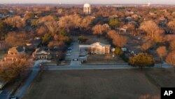 Esta toma aérea muestra vehículos policiales estacionados frente a la sinagoga de la Congregación Beth Israel, el domingo 16 de enero de 2022, en Colleyville, Texas. Un hombre mantuvo a cuatro personas como rehenes durante más de 10 horas el sábado dentro del templo.